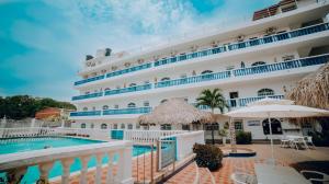 un crucero con piscina y sombrilla en Hotel Kevins, en Tolú