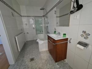 ein Badezimmer mit einem Waschbecken, einer Badewanne und einem WC in der Unterkunft Vita Gasthof in Rastenfeld