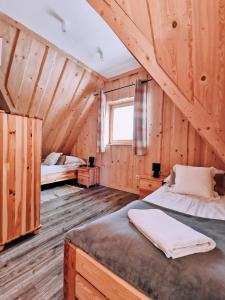 ザコパネにあるPodhalańska Chatkaの木造キャビン内のベッドルーム1室(ベッド2台付)