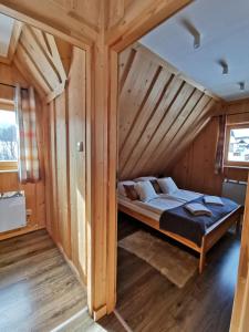 łóżko na poddaszu drewnianego domu w obiekcie Podhalańska Chatka w Zakopanem