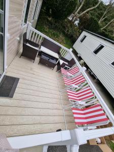 two lawn chairs and a table on a porch at 3 Bedroom Caravan, Sleeps 8, at Parkdean Newquay Holiday Park in Newquay