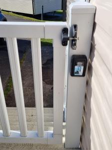 a white gate with a meter on the side of a house at 3 Bedroom Caravan, Sleeps 8, at Parkdean Newquay Holiday Park in Newquay
