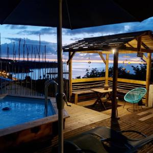 una terraza con piscina, mesa y sombrilla en Kreyol Lodges - Suite Kayou en Deshaies