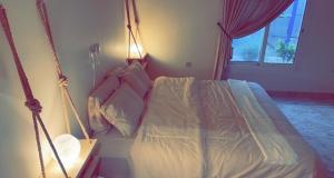 una camera da letto con letto a dondolo e finestra di شاليهات 4U vip a Dammam