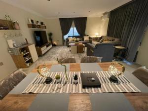 uma sala de estar com uma mesa e um sofá em شاليهات 4U vip em Dammam