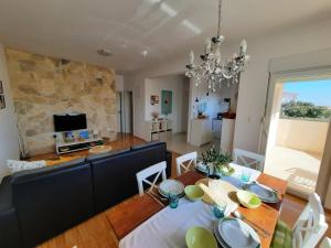 a dining room and living room with a table and a couch at Bella Mandre in Mandre