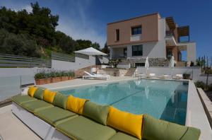 a swimming pool in front of a house at MARAVILLA SUITES in Paleo Tsifliki