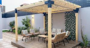 a wooden deck with chairs and a wooden pergola at شاليهات 4U vip in Dammam