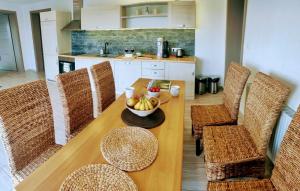 una cocina con una mesa de madera con sillas y un bol de fruta en Dva Duby, en Nána