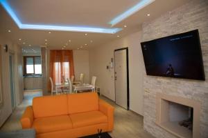 sala de estar con sofá naranja y chimenea en B&b Miramare Taranto, en Taranto