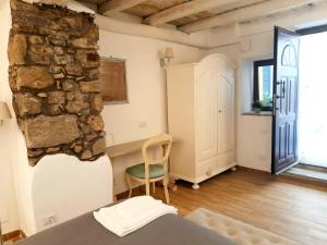 a room with a stone wall and a chair at Livia's Charming Room in Trevignano Romano