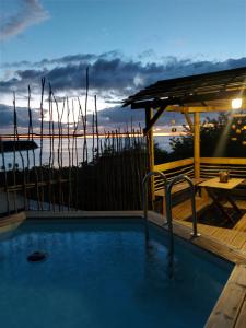 a swimming pool with a view of the ocean at dusk at Kreyol Lodges - Suite Kayou in Deshaies