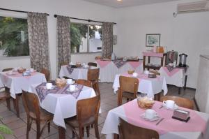 un comedor con mesas y sillas con manteles blancos en HOTEL DEL NORTE en Artigas