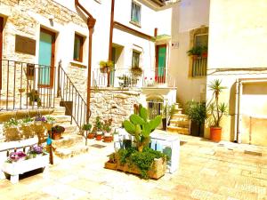 cortile con piante in vaso di fronte a un edificio di Antiche Mura Apartments"Nido di Puglia" monovano a Turi