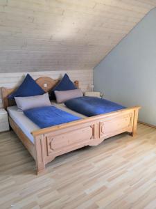 a bedroom with a large wooden bed with blue sheets at Ferienwohnung Auszeit mit viel Ruhe und Natur in Untrasried