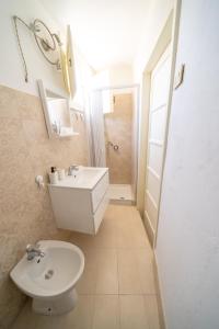 a bathroom with a white toilet and a sink at VICOLO A MARE in Siracusa