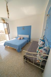 a bedroom with two beds and a blue and white wall at VICOLO A MARE in Siracusa