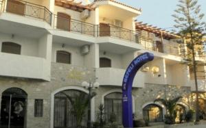 a building with a blue arch in front of it at Nefeli Hotel in Karlovasi