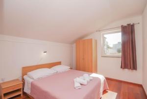 a bedroom with a bed with two towels on it at Apartmani Horvat in Jezera