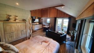 a living room with a bed and a kitchen at B&B Hertenhoef, Fluitenberg (Hoogeveen) in Fluitenberg
