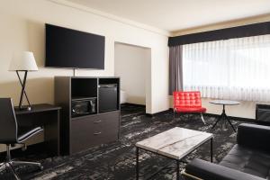 a hotel room with a couch and a flat screen tv at Centennial Hotel Spokane in Spokane