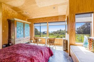 1 dormitorio con cama y ventana grande en Wild Meadow, en Sea Ranch