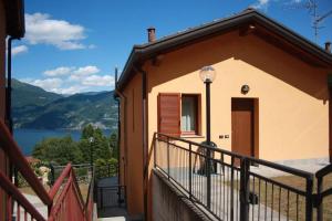 a house with a balcony with a view of a lake at Piscina e vistalago CroceMenaggio CIR 013145-00318 in Menaggio