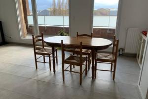 - une table et des chaises en bois dans une chambre avec fenêtre dans l'établissement Grand appartement lumineux au coeur de Saint Malo, à Saint-Malo