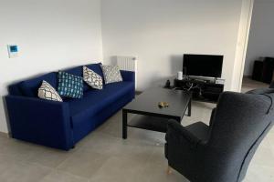 - un salon avec un canapé bleu et une table dans l'établissement Grand appartement lumineux au coeur de Saint Malo, à Saint-Malo