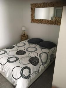 een slaapkamer met een bed met een zwart-witte deken bij L’appartement charmant in Dole