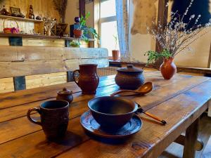 a wooden table with cups and spoons on it at Эко-хутор "Ряйсяля-Райский Сад" in Mel'nikovo