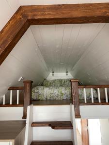 an attic room with a bed and wooden beams at The Big Tiny House in Lurgan