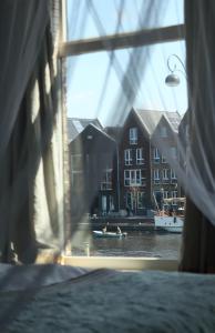 a window with a view of a river and buildings at RiverSide Suite - Haarlem City Centre in Haarlem +39 photos