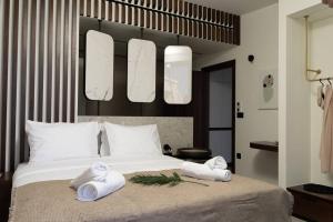 a bedroom with a bed with two towels on it at THE WAVE TWIN VILLA 2 KATHISMA BEACH Lefkada in Lefkada Town