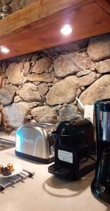 a toaster sitting on a counter next to a stone wall at Les Bergeries de Piazzagina in Piediquarciu