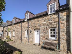 an old stone building with a bench in front of it at Middle Cottage in Newport Pembrokeshire