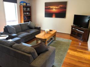 sala de estar con sofá y TV en Chill Apartment, en Rye