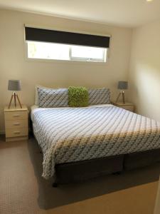 a bedroom with a bed and two lamps and a window at Chill Apartment in Rye