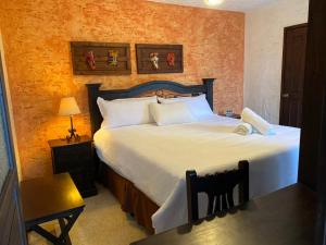 a bedroom with a large bed with white sheets at Hotel Posada San Pedro in Antigua Guatemala