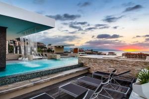 a pool on the roof of a building with chairs at Condominio Loft 268 Zona Romántica Departamento 510 in Puerto Vallarta