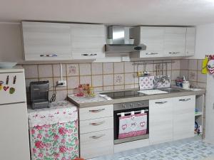 a small kitchen with white cabinets and a refrigerator at Sole...Mare...e...Spiaggie Bianche! in Vada