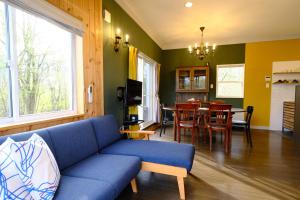 a living room with a blue couch and a table at ヒウチバコ in Fujikawaguchiko