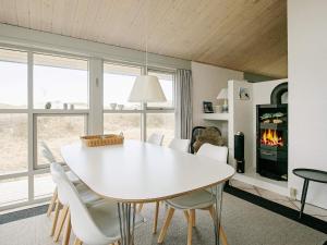 a dining room with a white table and chairs at Three-Bedroom Holiday home in Pandrup 8 in Blokhus
