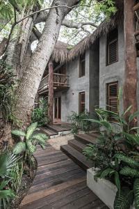 a large stone building with trees and a balcony at Hotel Casa Hormiga in Bacalar