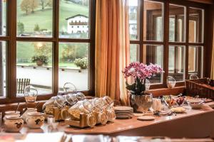 a table with glasses and plates on it with windows at Haus Kathrin in Werfenweng