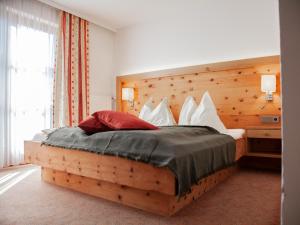a bedroom with a large bed with a wooden headboard at Haus Kathrin in Werfenweng