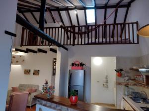 a living room with a refrigerator and a staircase at Apartamento Balcones de La Villa 2 in Villa de Leyva