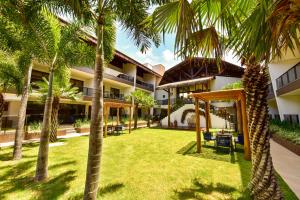 a courtyard of a hotel with palm trees at Porto das Dunas Boutique Praia Hotel in Aquiraz