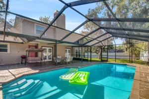 una piscina con dosel sobre una casa en Tampa Bay Pool Home with Heated Pool en Brandon