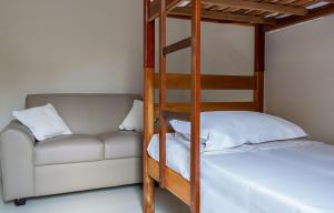 Una cama o camas en una habitación de Casa com churrasqueira e jardim perto da praia